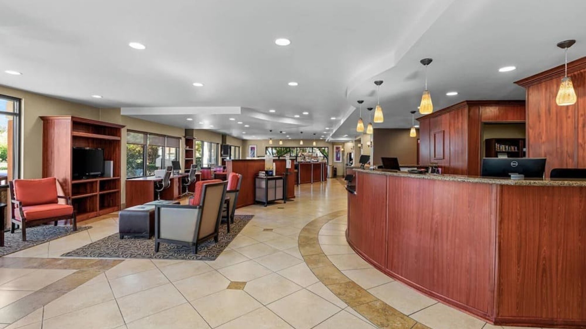 Spacious reception and lobby area featuring the front desk, guest seating, and warm pendant lighting at Comfort Suites Vacaville-Napa Valley Area.