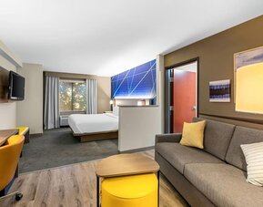 Bright suite featuring a separate living area with a sofa and workspace alongside the sleeping area at Comfort Suites Vacaville-Napa Valley Area.