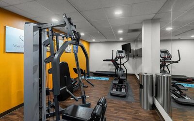 Fitness centre featuring strength-training equipment, cardio machines, mirrored walls, and ample workout space at Comfort Suites Vacaville-Napa Valley Area.