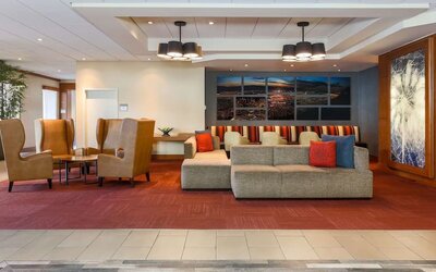 Contemporary hotel lobby featuring sofas, armchairs, colourful accent cushions, artwork, and multiple seating areas at Hyatt Place San Jose Downtown.