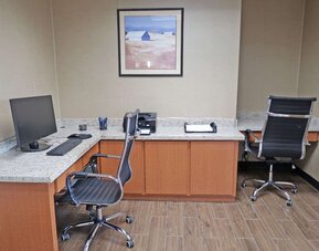 Business centre featuring computer workstations, office chairs, a printer, and countertop workspace at Comfort Inn Southwest At Westpark.
