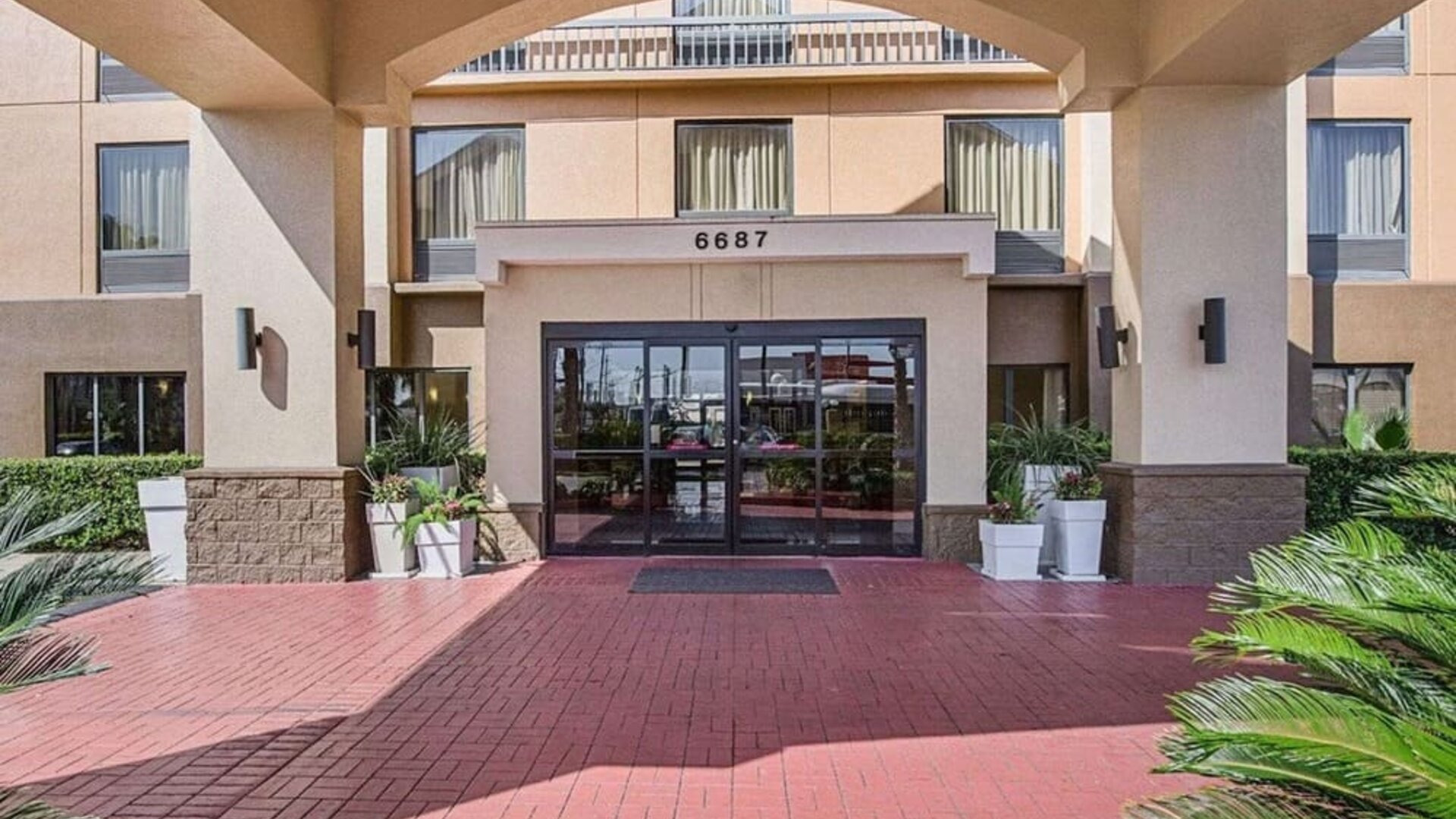 Covered front entrance featuring landscaped surroundings and glass entry doors at Comfort Inn Southwest At Westpark.