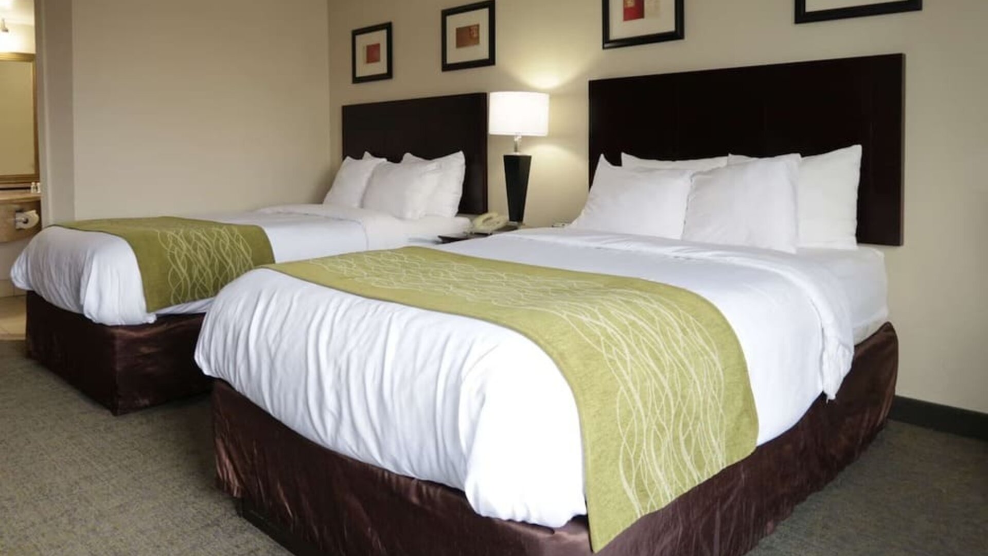 Spacious guest room featuring a king bed, sofa seating area, coffee table, workspace, and large window at Comfort Inn Southwest At Westpark.