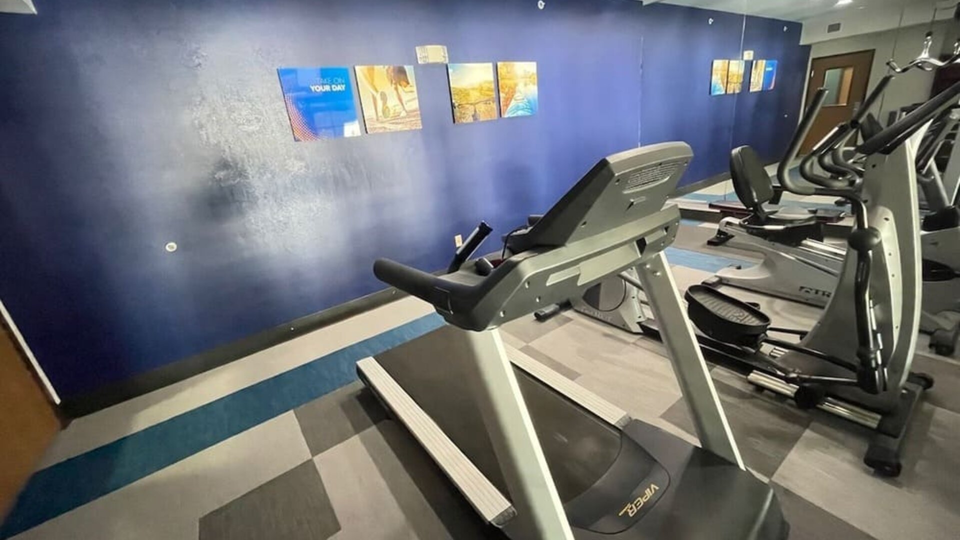Fitness centre with treadmill, elliptical machines, exercise bike, and mirrored wall at Comfort Suites San Antonio SeaWorld - Lackland AFB.