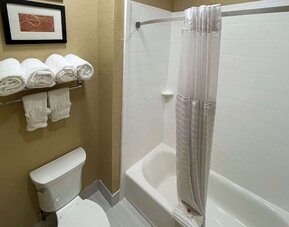 Guest bathroom vanity with two sinks, illuminated mirror, granite countertop, toiletries, and hair dryer at Comfort Suites San Antonio SeaWorld - Lackland AFB.