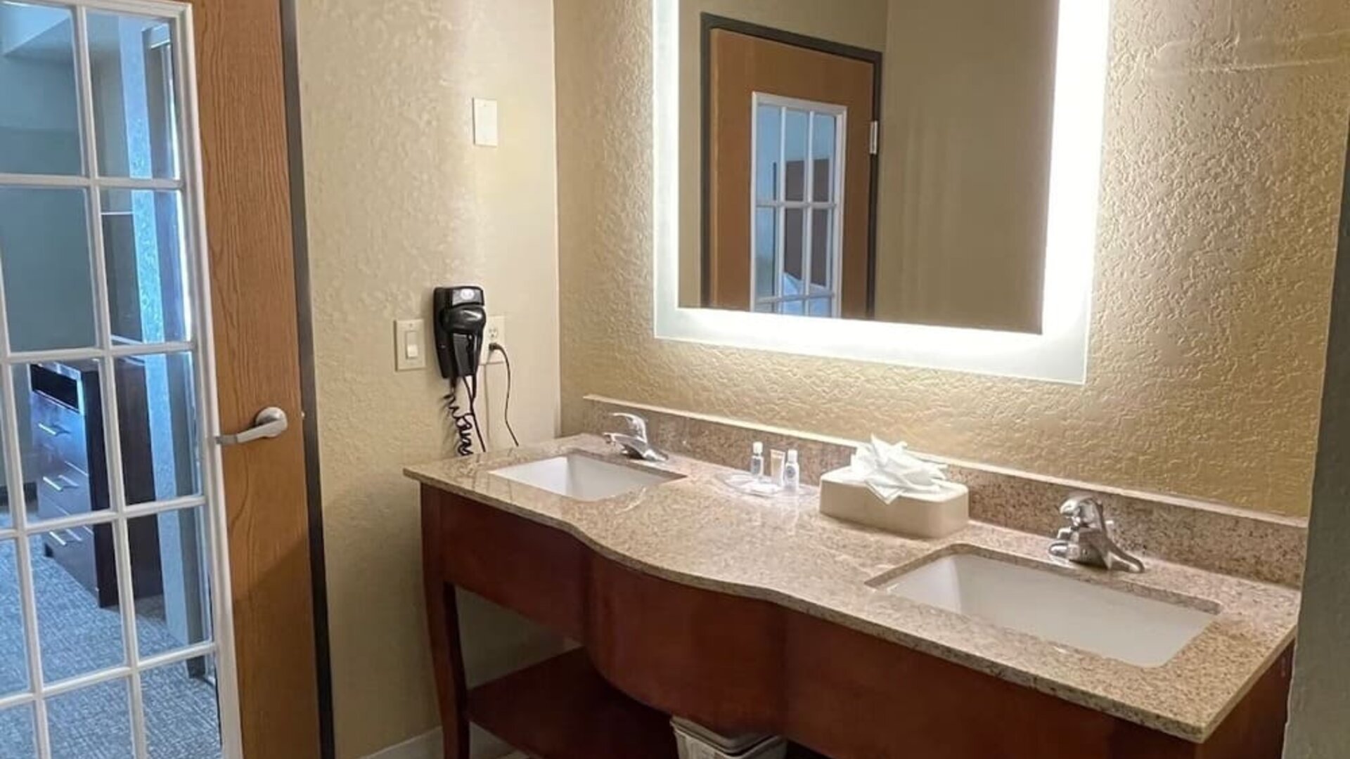 Guest bathroom with bathtub and shower, toilet, fresh towels, and tiled surround at Comfort Suites San Antonio SeaWorld - Lackland AFB.