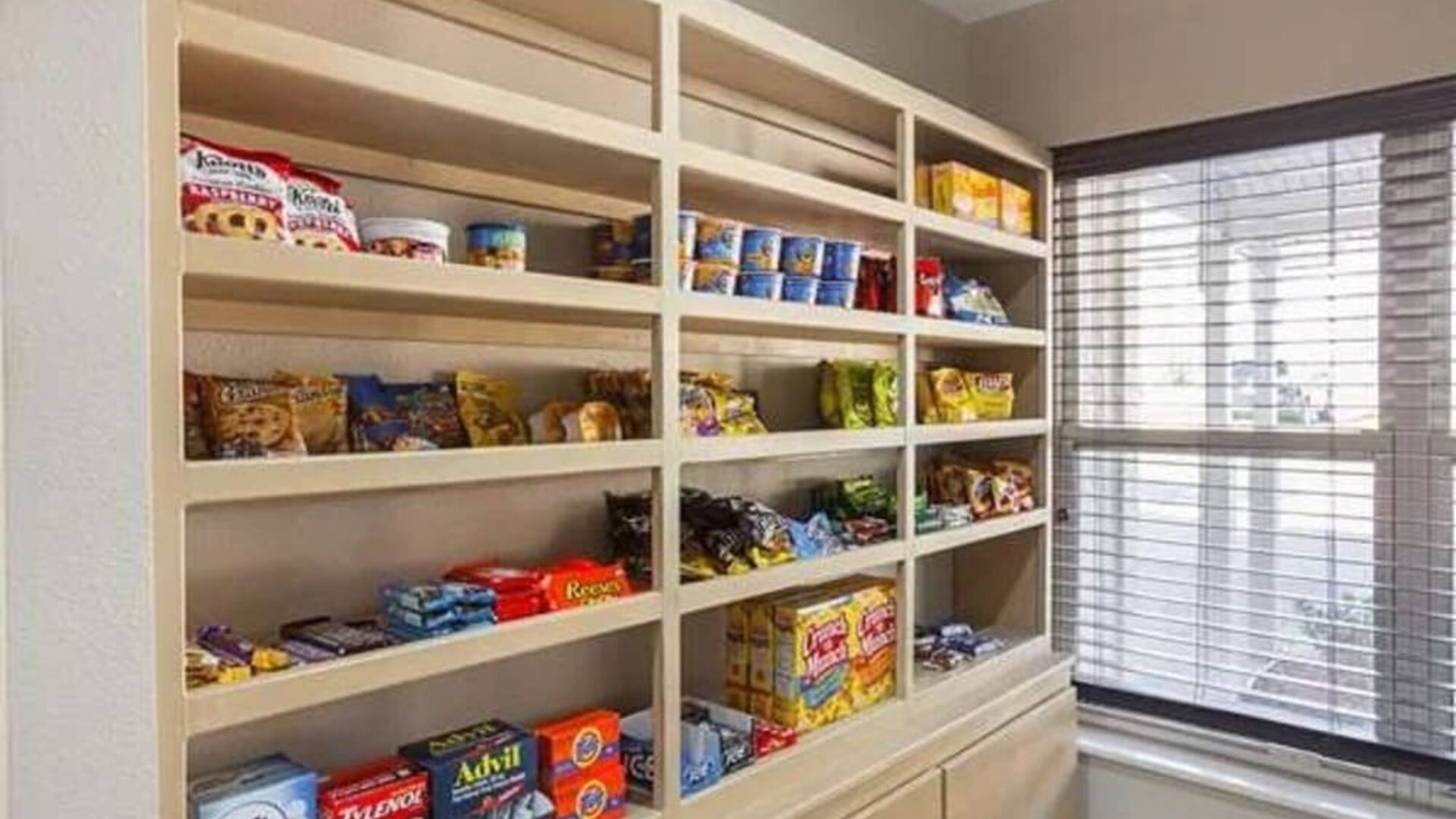 Hotel convenience area with shelves stocked with snacks, drinks, and travel essentials at SureStay by Best Western Lewisville Dallas.