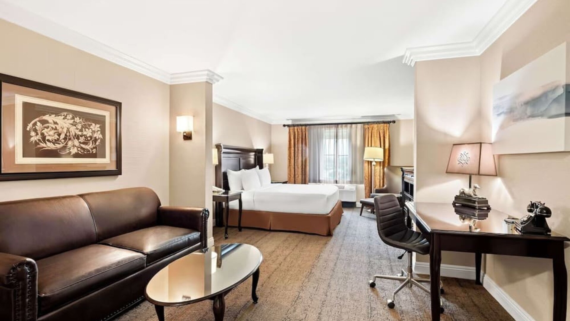 Spacious guest room with king bed, sofa, coffee table, work desk, and seating area at Best Western Ontario Mills Mall.