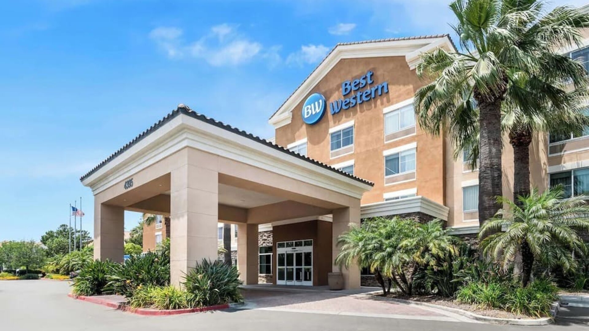 Exterior entrance with covered driveway, palm trees, and Best Western signage at Best Western Ontario Mills Mall.