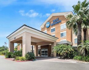 Exterior entrance with covered driveway, palm trees, and Best Western signage at Best Western Ontario Mills Mall.