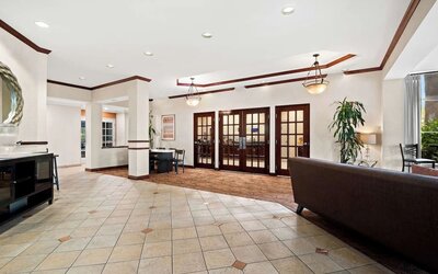 Spacious hotel lobby with tiled floors, seating areas, and French doors at Best Western Ontario Mills Mall.