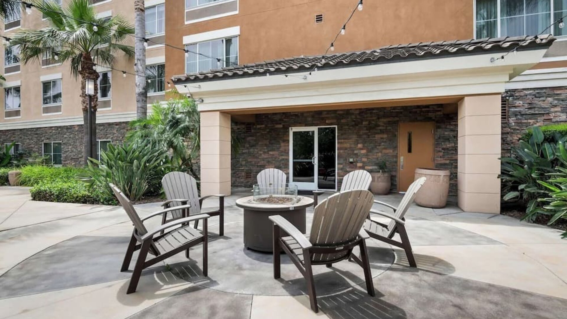 Outdoor terrace with chairs arranged around a fire pit at Best Western Ontario Mills Mall.