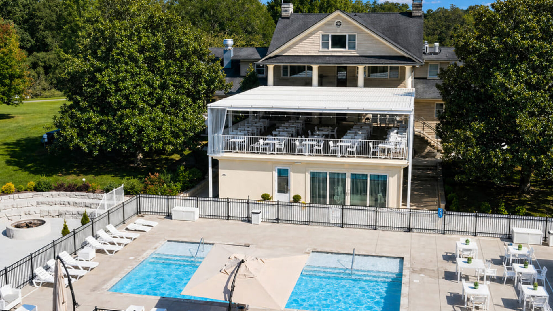 Outdoor pool area featuring multiple swimming pools, sun loungers, terrace seating, and the main resort building at SKYLARANNA Resort & Spa.
