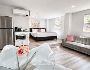 Spacious guest accommodation featuring a bed, sofa, dining area, refrigerator, kitchenette, and contemporary furnishings at SKYLARANNA Resort & Spa.