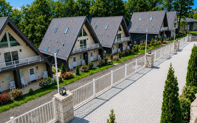 Exterior view featuring chalet-style guest buildings, landscaped grounds, and a paved walkway at SKYLARANNA Resort & Spa.