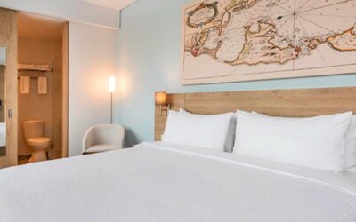 Comfortable king guest room featuring a large bed, contemporary furnishings, and map-inspired wall artwork at Holiday Inn Express Cartagena Manga.