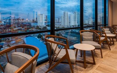 Comfortable lounge seating beside floor-to-ceiling windows overlooking the city and port at Holiday Inn Express Cartagena Manga.