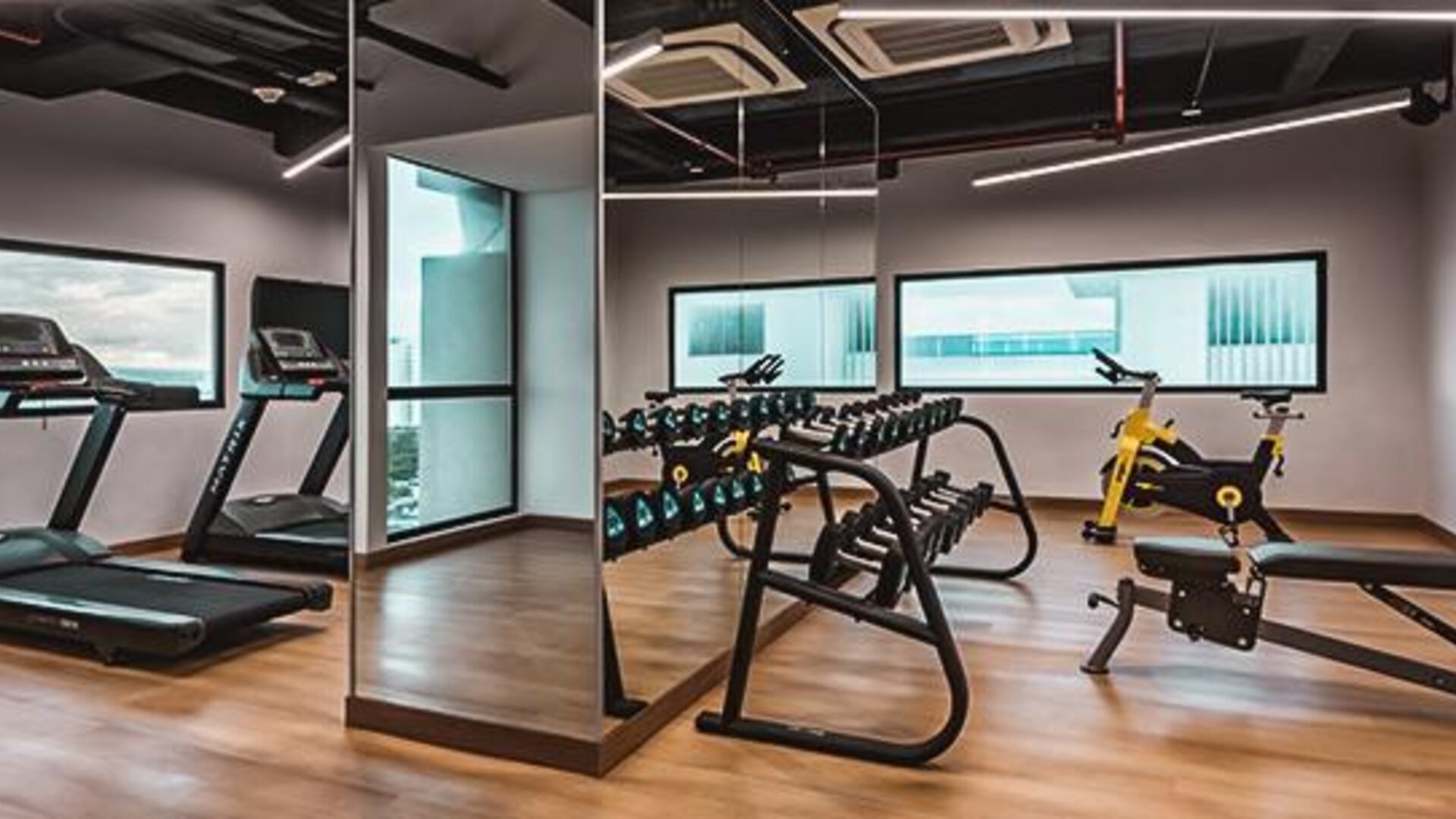 Modern fitness centre featuring treadmills, exercise bikes, free weights, and strength-training equipment at Holiday Inn Express Cartagena Manga.