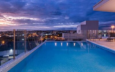 Rooftop outdoor swimming pool featuring panoramic city views and poolside loungers at sunset at Holiday Inn Express Cartagena Manga.