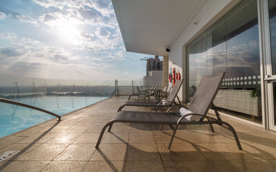 Rooftop pool deck featuring sun loungers, glass railings, and expansive views at Holiday Inn Express Cartagena Manga.