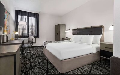 Comfortable guest room featuring a king bed, dedicated work desk, television, wardrobe, and contemporary décor at La Quinta Inn & Suites By Wyndham Cleveland Airport West.