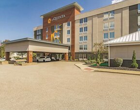 Exterior view of La Quinta Inn & Suites By Wyndham Cleveland Airport West featuring the hotel entrance, covered drop-off area, and landscaped surroundings.