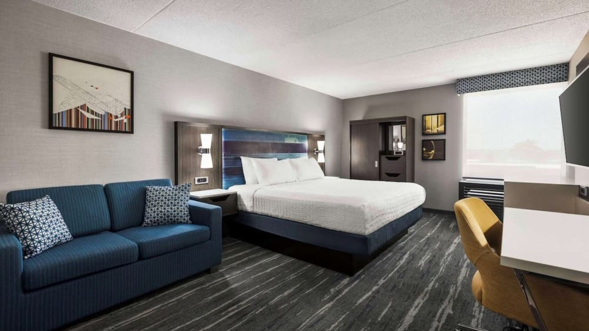 Spacious day use room with sofa and work desk at Hampton Inn Chicago O`Hare.