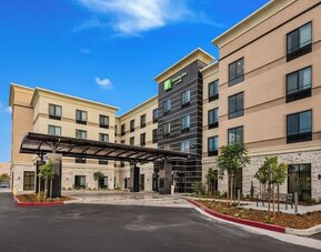 Exterior view of Holiday Inn & Suites Silicon Valley - Milpitas featuring the modern hotel building and covered entrance.