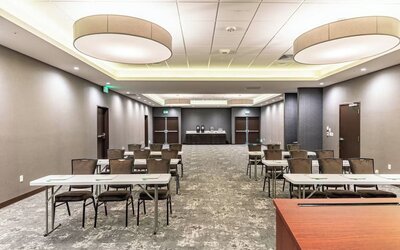 Spacious meeting facility featuring classroom-style tables and chairs, presentation space, and modern lighting at Holiday Inn & Suites Silicon Valley - Milpitas.