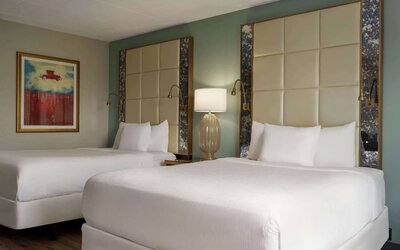 Comfortable guest room featuring two beds, contemporary headboards, bedside lighting, and modern décor at Wyndham Garden Pittsburgh Airport.