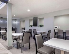 Modern dining area featuring multiple tables, comfortable chairs, counter seating, and bright overhead lighting. Best Western McCarran Inn.