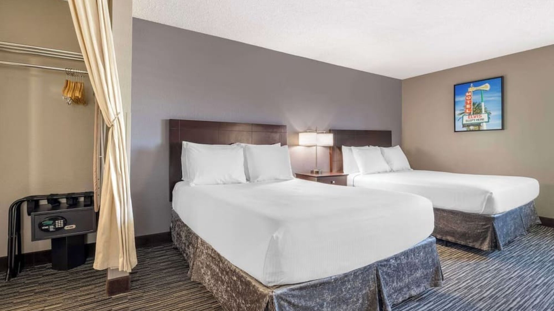 Guest room featuring two beds, bedside lighting, an in-room safe, and open wardrobe area. Best Western McCarran Inn.