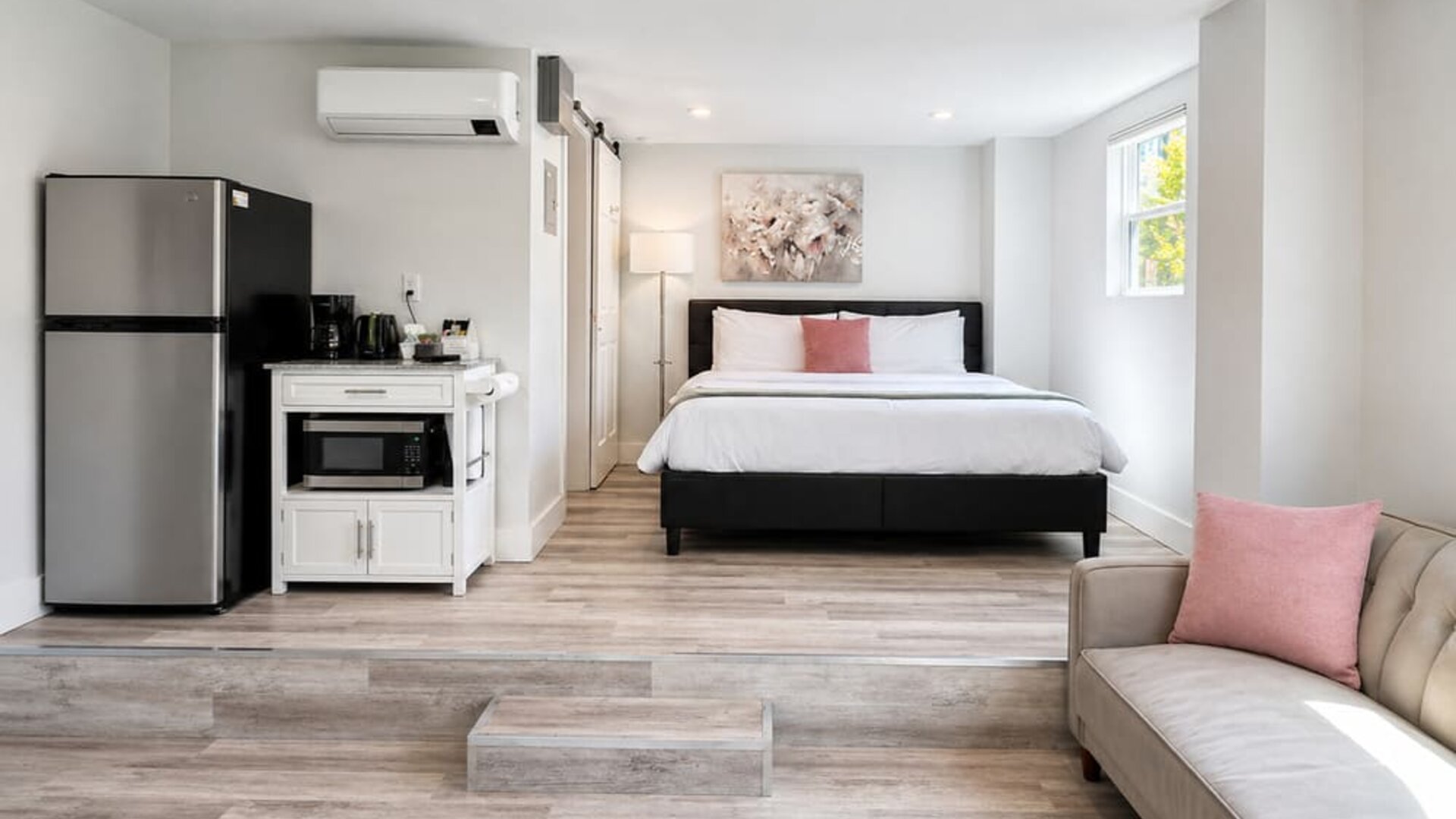 Spacious guest accommodation featuring a bed, sofa, dining area, refrigerator, kitchenette, and contemporary furnishings at SKYLARANNA Resort & Spa.