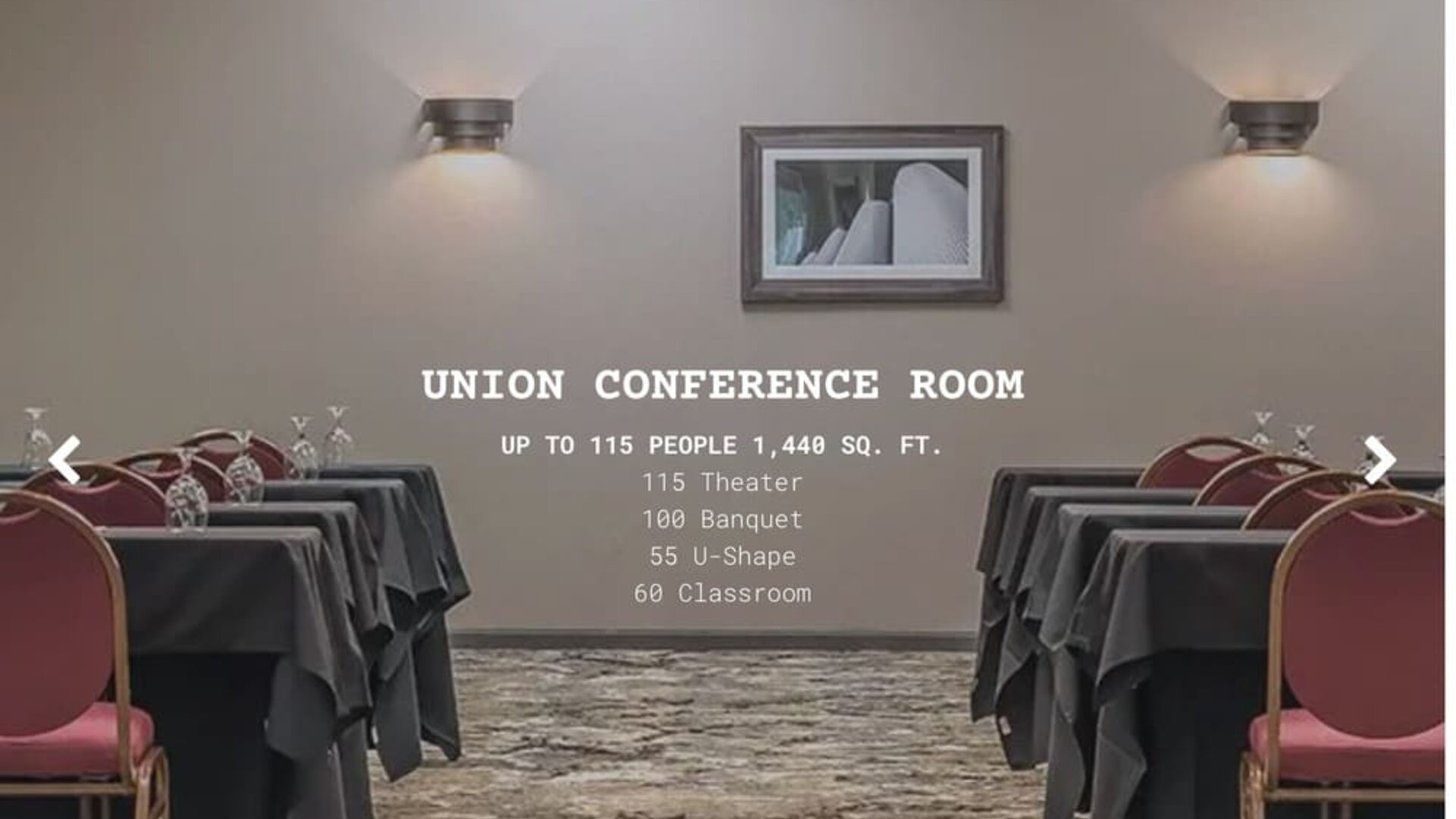 Conference room set up for meetings and events with banquet tables and red chairs at EnVision Hotel St. Paul South.
