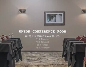 Conference room set up for meetings and events with banquet tables and red chairs at EnVision Hotel St. Paul South.