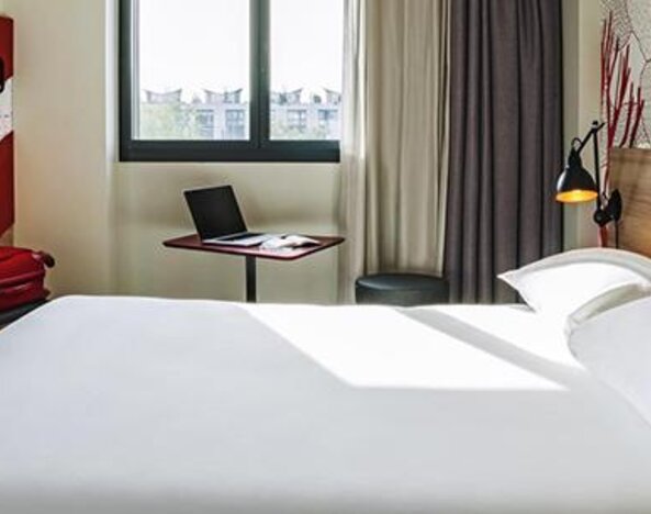 Guest room with a double bed, television, desk, chair, bedside reading lamps, and large window at Hotel ibis Styles Barcelona City Bogatell.
