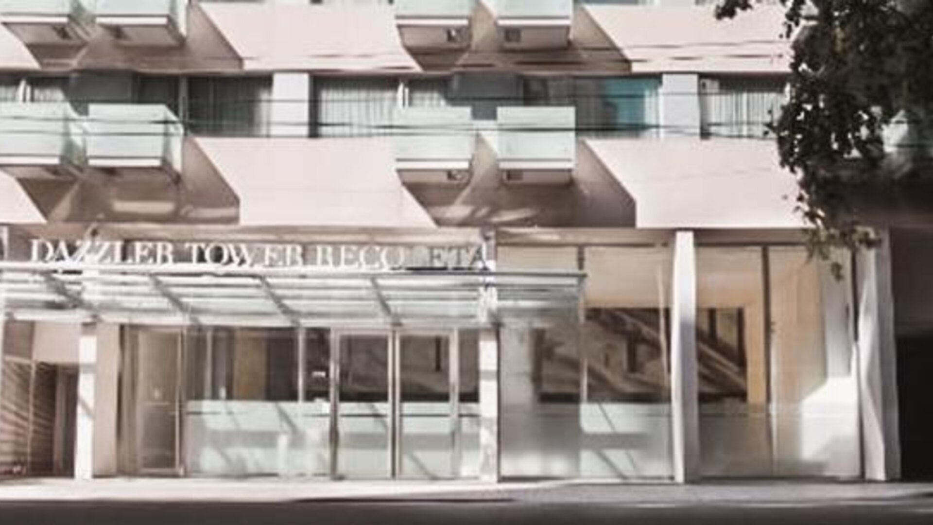 Hotel entrance with glass doors, covered canopy, balconies, and signage above the entrance at Dazzler by Wyndham Buenos Aires Recoleta.