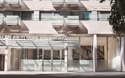 Hotel entrance with glass doors, covered canopy, balconies, and signage above the entrance at Dazzler by Wyndham Buenos Aires Recoleta.