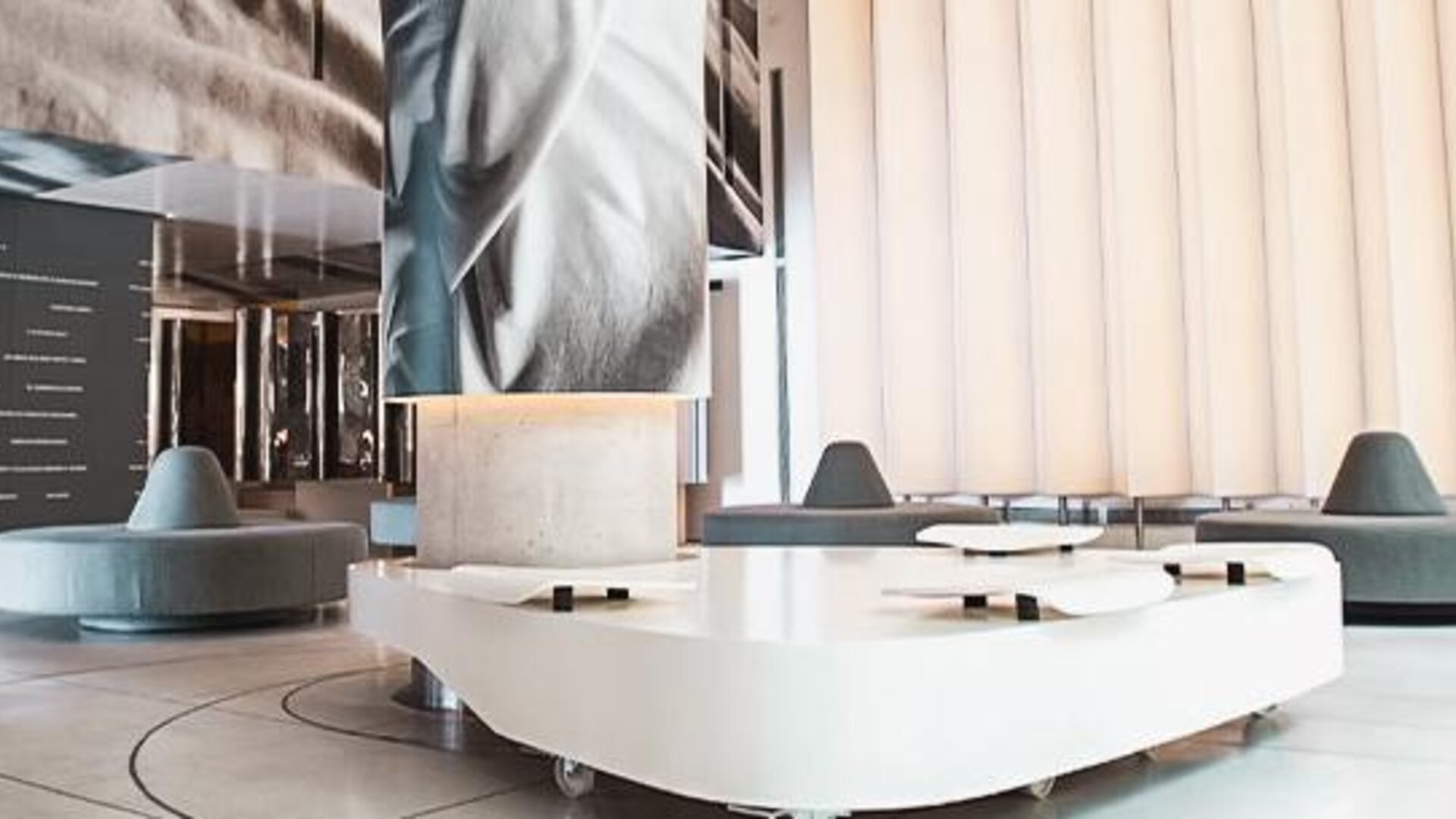 Modern hotel lobby with sculptural white seating, large digital artwork, and floor-to-ceiling windows at Dazzler by Wyndham Buenos Aires Recoleta.
