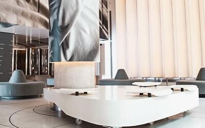Modern hotel lobby with sculptural white seating, large digital artwork, and floor-to-ceiling windows at Dazzler by Wyndham Buenos Aires Recoleta.