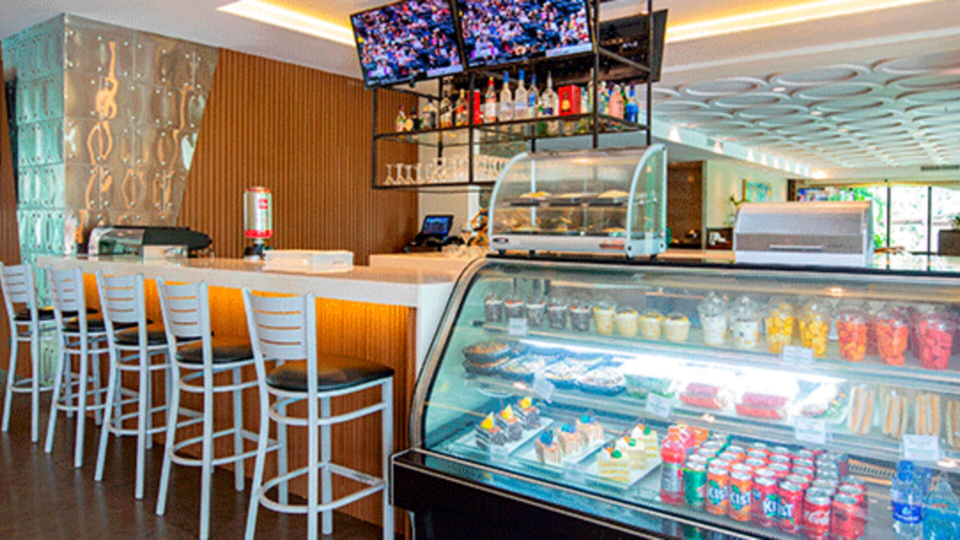 Hotel café and snack shop with a counter, refrigerated display case, high-top seating and refreshments at Holiday Inn Panama Canal.