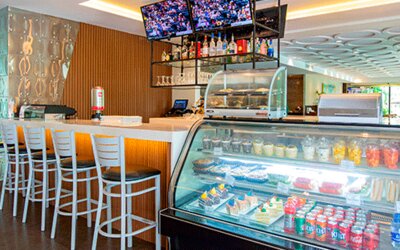 Hotel café and snack shop with a counter, refrigerated display case, high-top seating and refreshments at Holiday Inn Panama Canal.
