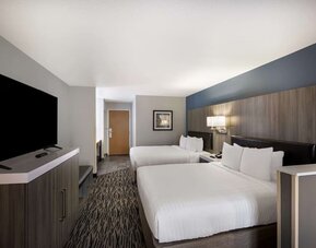 Guest room with two beds, a television, dresser, desk, and seating area at Best Western Plus Mountain View Auburn Inn.