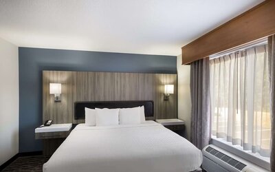King guest room with large bed, bedside lighting, desk, and window at Best Western Plus Mountain View Auburn Inn.