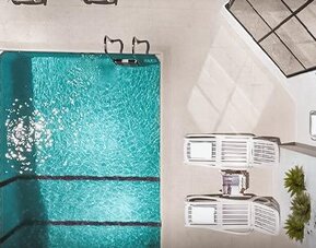Outdoor swimming pool viewed from above, surrounded by lounge chairs and a paved pool deck at Ramada by Wyndham Buenos Aires Centro.