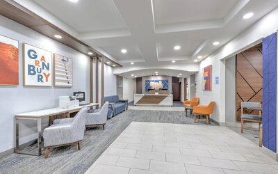 Hotel lobby and reception area with modern seating, colorful artwork, wood accents, and a front desk at Holiday Inn Express & Suites Granbury.