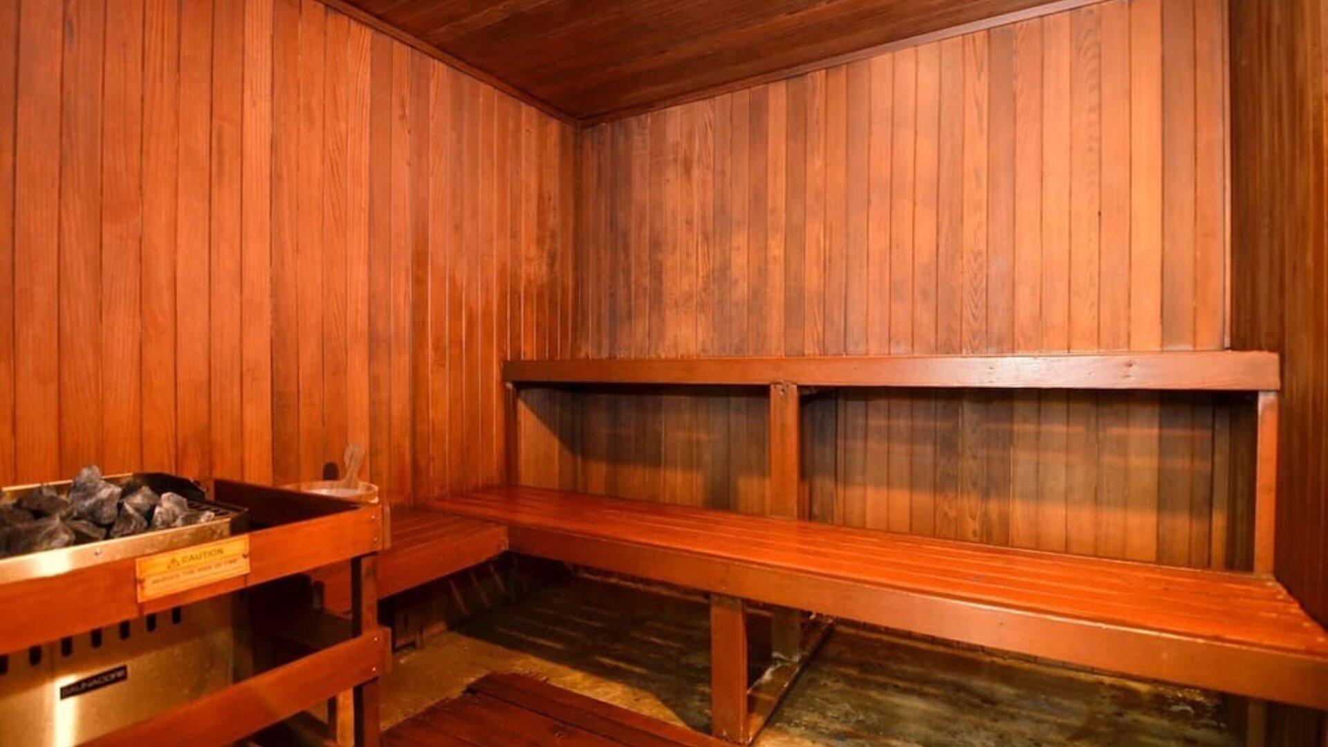 Wooden sauna room with timber walls, built-in benches, and an electric sauna heater at Best Western Plus BWI Airport Arundel Mills.