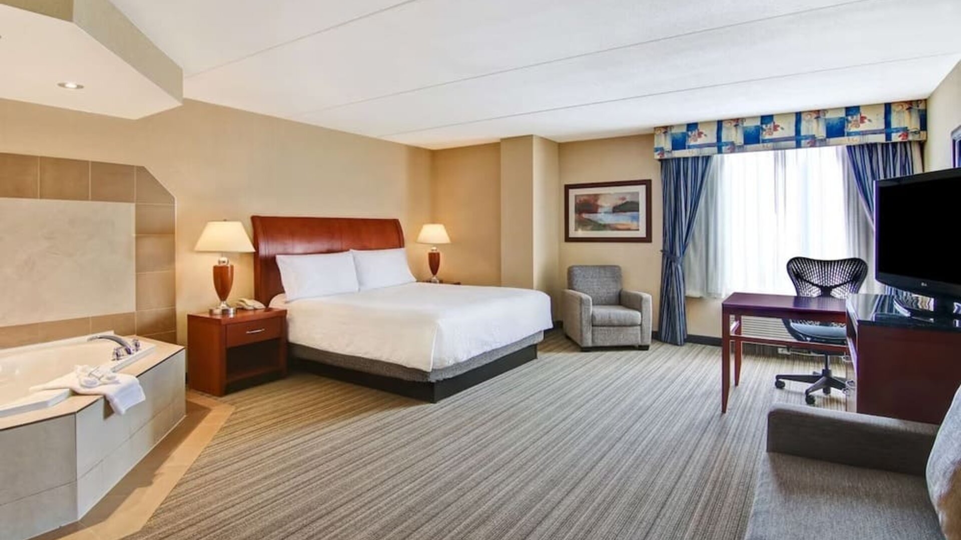 Day use room with TV, work desk, sofa and tub at Hilton Garden Inn Toronto/Burlington.