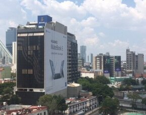 View of Mexico City’s modern skyscrapers and surrounding urban buildings through the windows at Hotel Block Suites.
