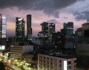 Panoramic nighttime view of Mexico City’s illuminated skyline and busy streets at Hotel Block Suites.